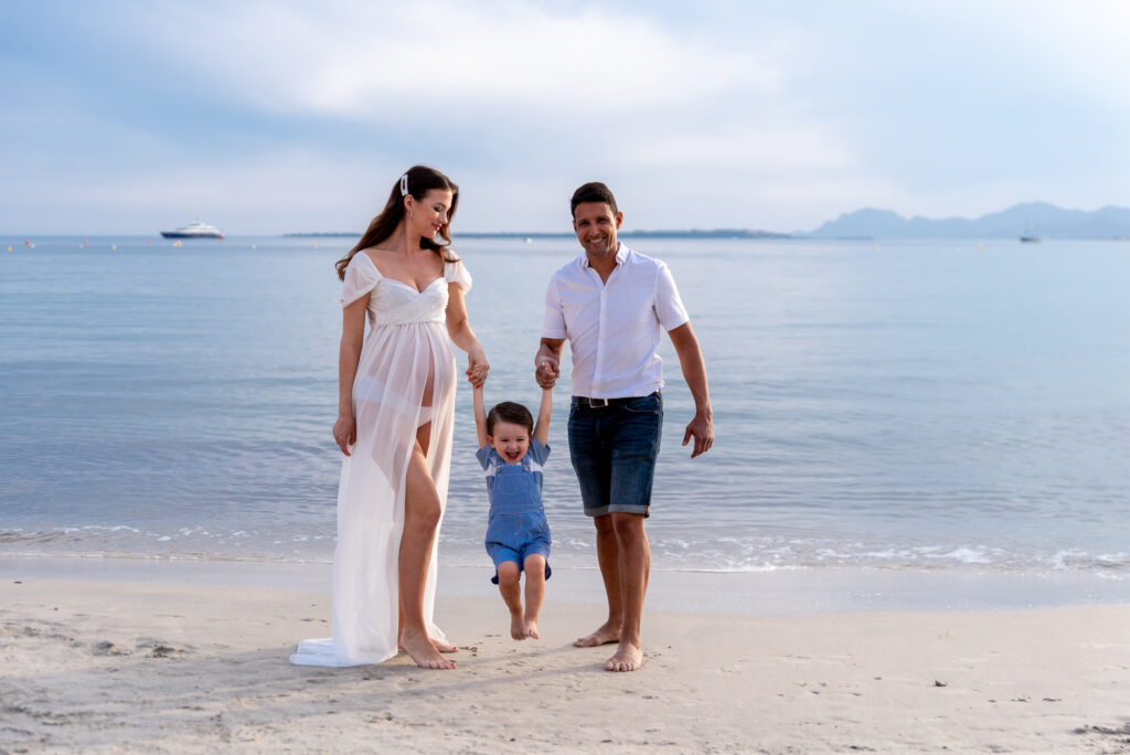 Embarazada con hijos disfrutando del atardecer en la playa