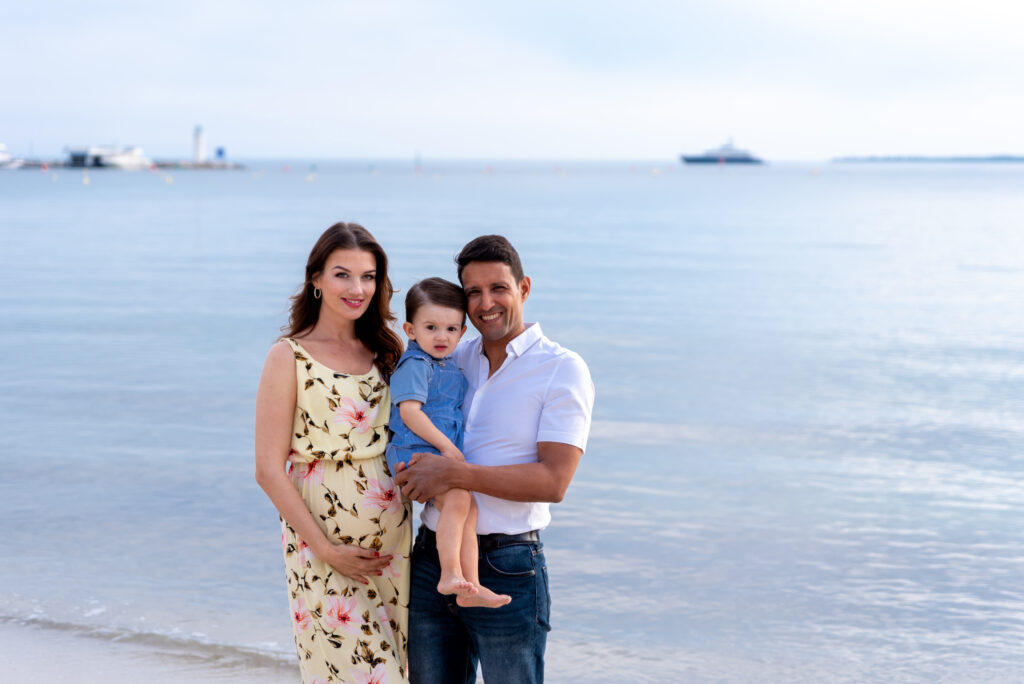 Embarazada y familia en la playa al atardecer en Valencia