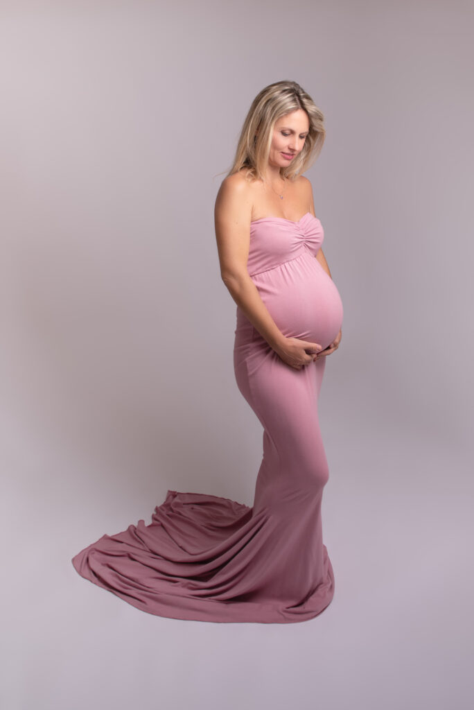 Fotos de embarazo elegantes en estudio con vestido largo