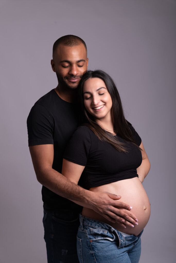 Fotos de embarazo en estudio con pareja abrazada