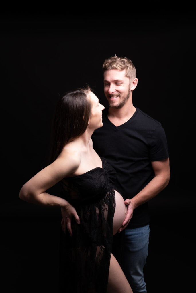Fotos de embarazo en estudio con pareja y fondo negro