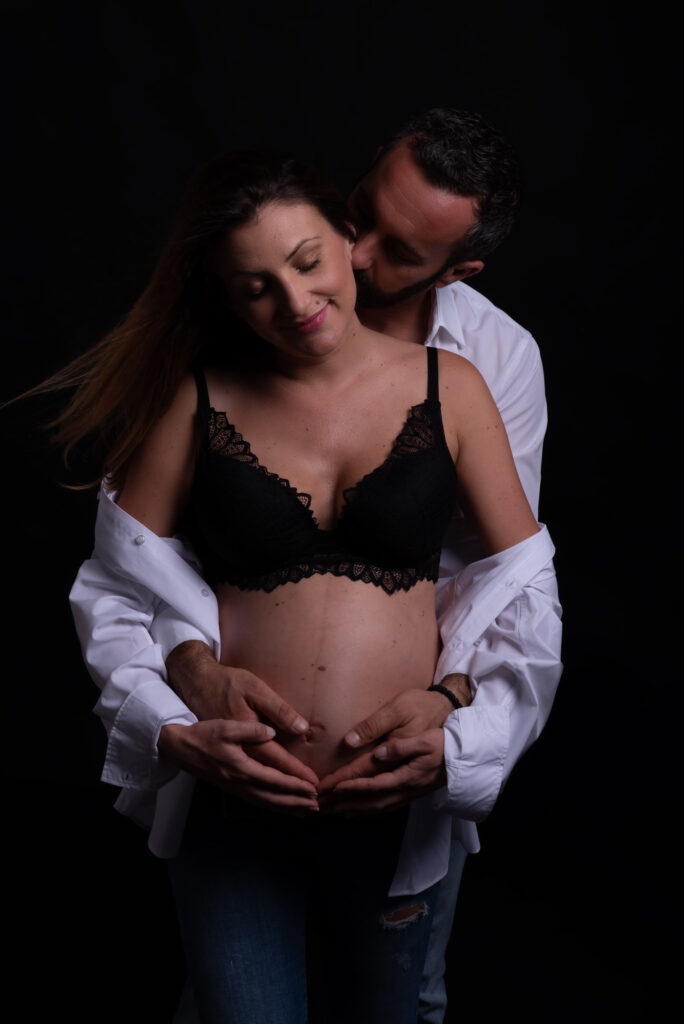 Fotos de embarazo en estudio con pareja y fondo oscuro