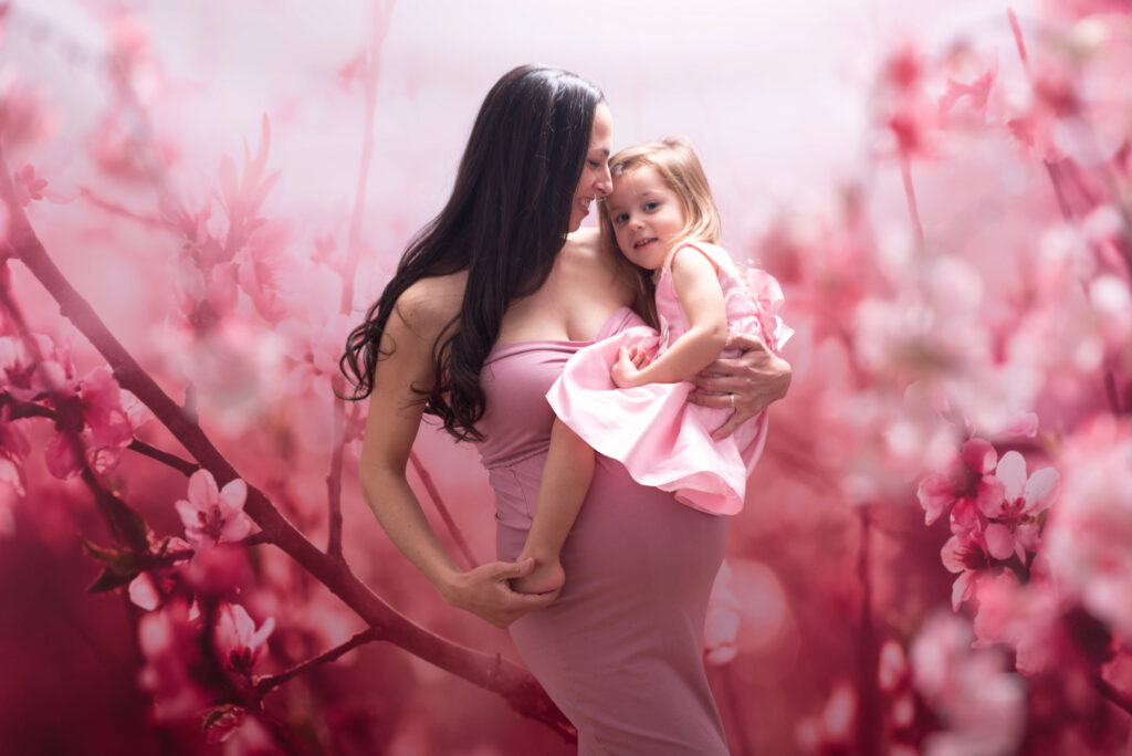 Sesión de fotos de embarazo en estudio con flores y con niña pequeña