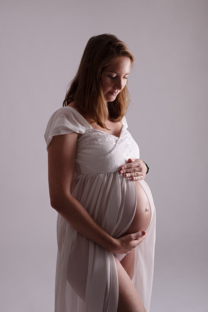Sesión de fotos de embarazo en estudio con luz tenue y suave