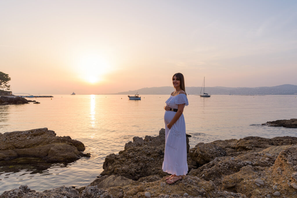 Sesión de fotos de embarazo en la playa al atardecer