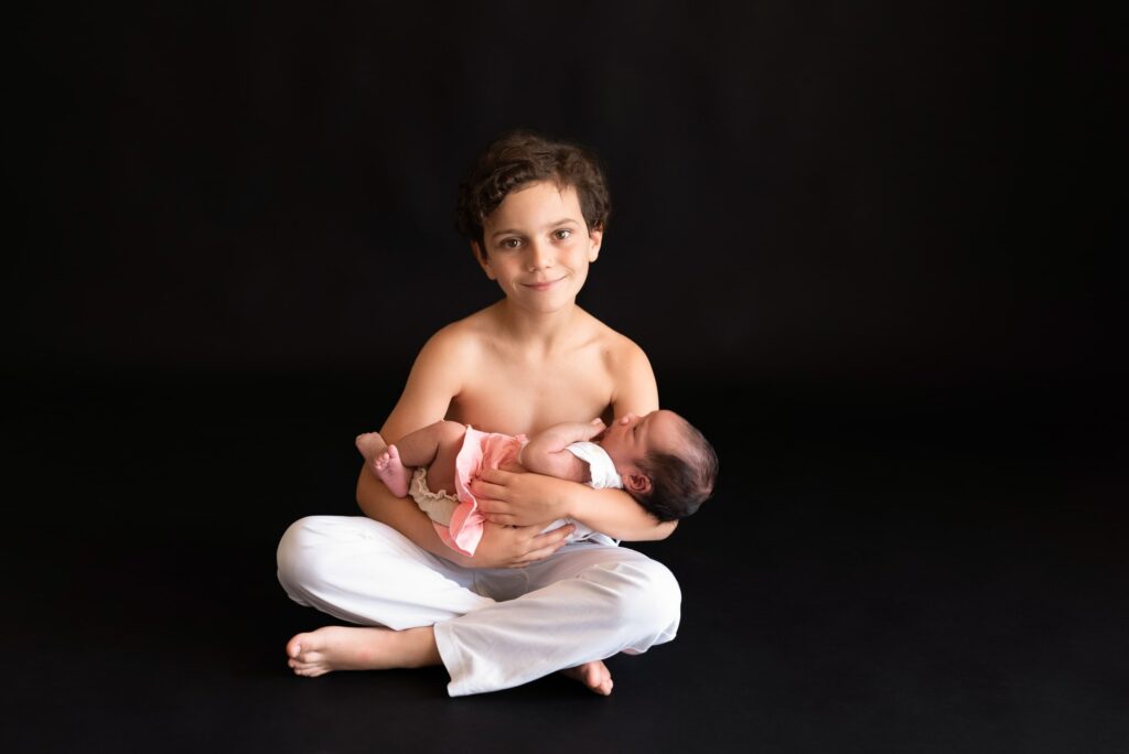 Fotografía de bebé con su hermanito en fondo oscuro Valencia